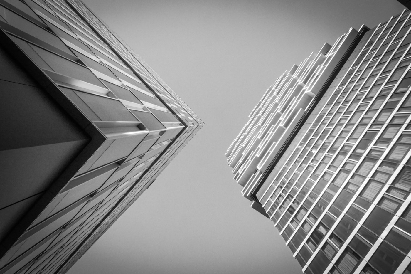 Deux tours de verre vues en contre-plongée, se rejoignant vers le ciel.
